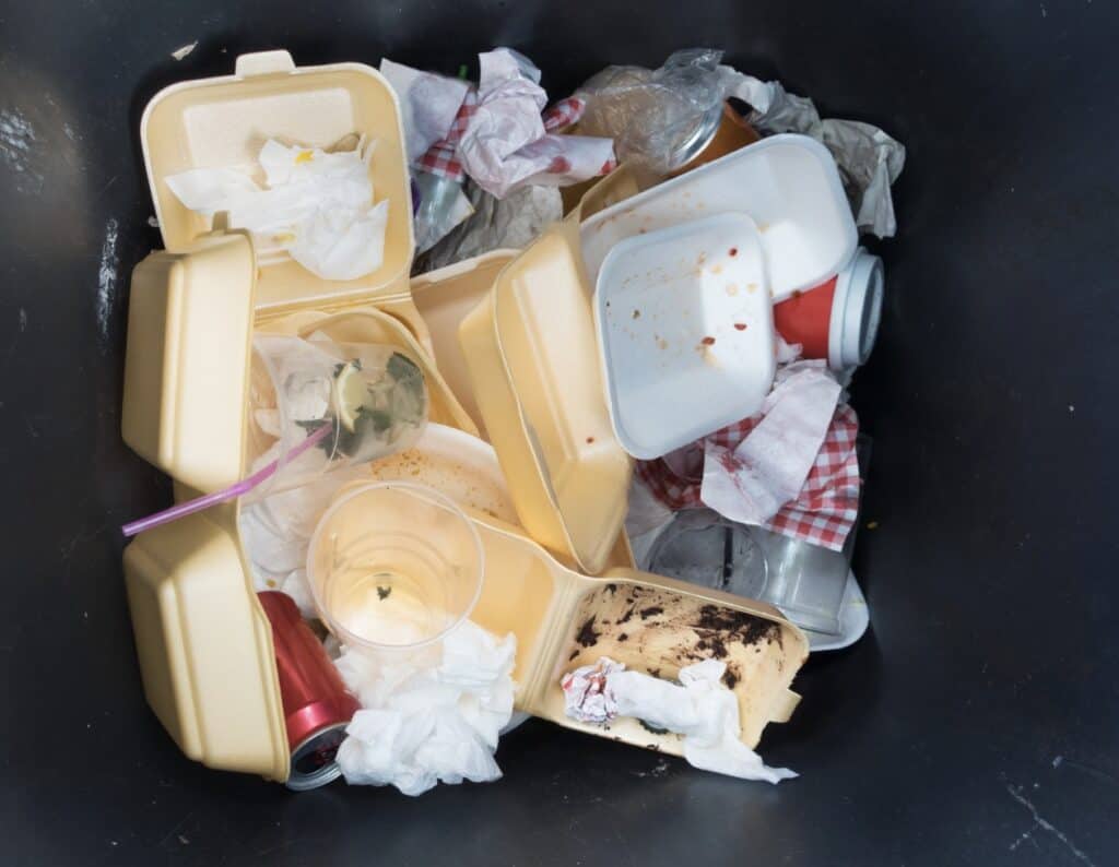 plastic food containers in the trash